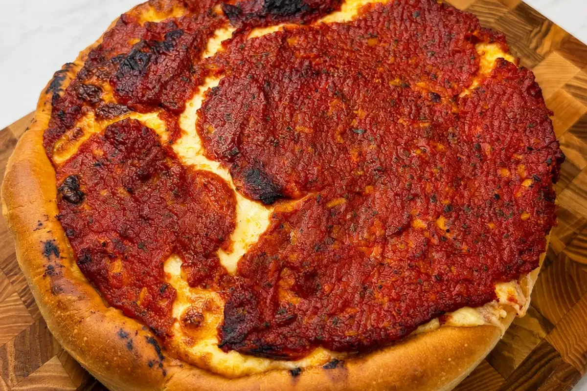 Chicago Deep Dish Pizza to kultowa pizza z Chicago pieczona w wysokiej formie. Ma chrupiące, maślane ciasto, dużą ilość ciągnącej mozzarelli, ostre salami oraz gęsty sos pomidorowy ułożony na wierzchu. Podana porcja składników wystarcza na dwie pizze o średnicy 26 cm.
